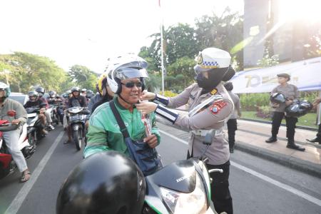 Gatur Lalin Sambil Berbagi Helm dan Cokelat Polwan Polda Jatim Peringa